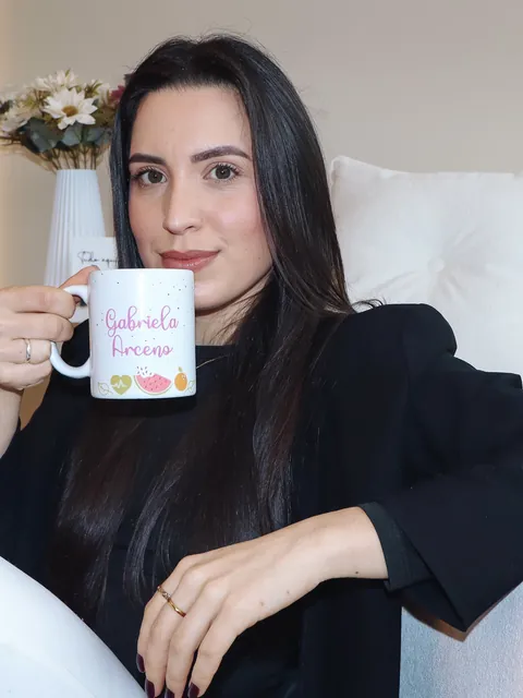 Gabriela Arceno, nutricionista, segurando uma caneca com seu nome
